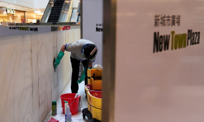 Workers clean graffiti at New Town Plaza in Sha Tin, Hong Kong, China on Sept. 23, 2019. (Aly Song/Reuters)
