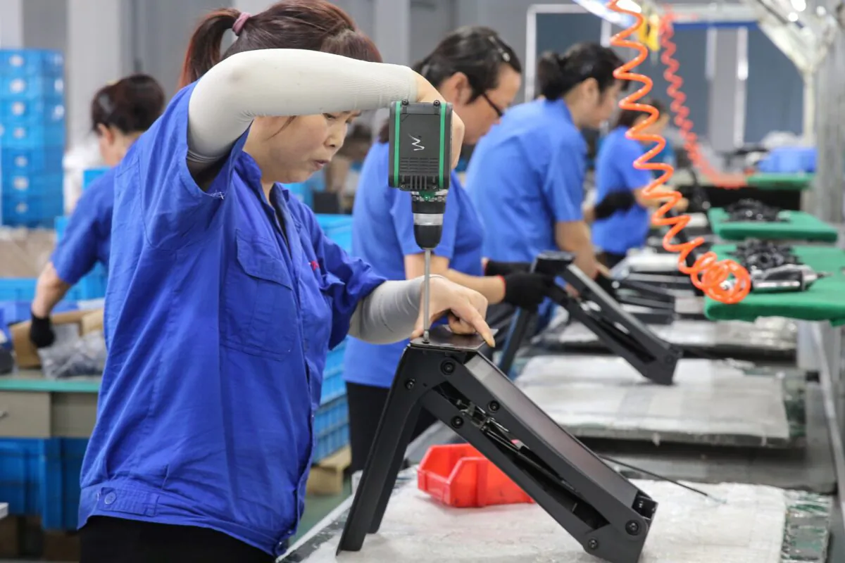Workers produce desks for export to the United States, France, Germany, and other countries, at a factory in Nantong in China's eastern Jiangsu Province on Sept. 4, 2019. (STR/AFP/Getty Images)