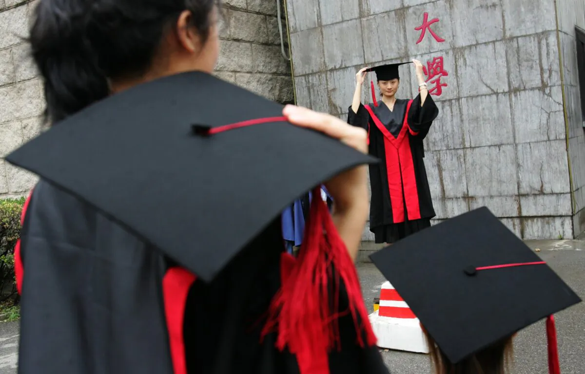 Graduates pose for pictures during a graduation ceremony at Renmin University in Beijing on June 29, 2006. Chinese investor Zhang Lei has donated millions to Renmin University to establish an artificial intelligence research institute. (China Photos/Getty Images)