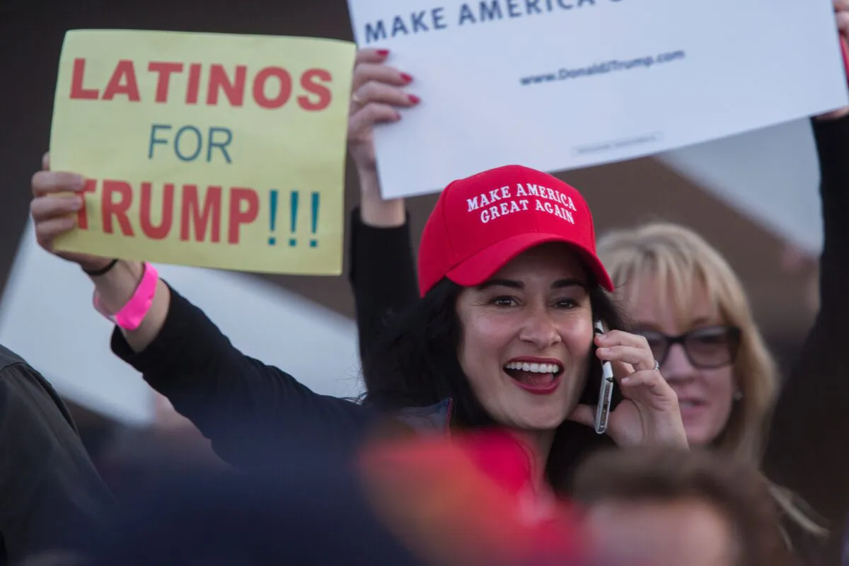 A woman holds a sign expressing Latino support for then-Republican presidential candidate Donald Trump at his campaign rally at the Orange County Fair and Event Center, April 28, 2016, in Costa Mesa, California. (DAVID MCNEW/AFP/Getty Images)