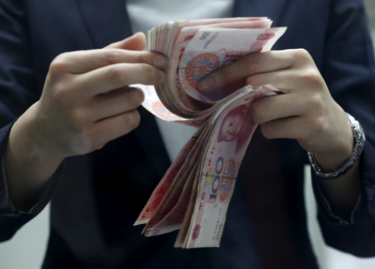 A clerk counts Chinese 100 yuan banknotes at a branch of a foreign bank in Beijing on Jan. 4, 2016. (Kim Kyung-Hoon/Reuters)