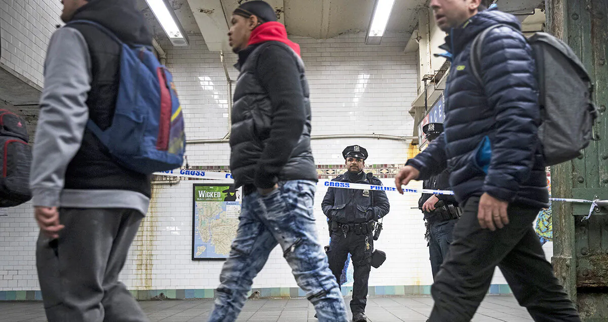 Commuters exit a train as a police officer stands in a cordoned off subway station walkway in New York, on Dec. 11, 2017. (Drew Angerer/Getty Images)