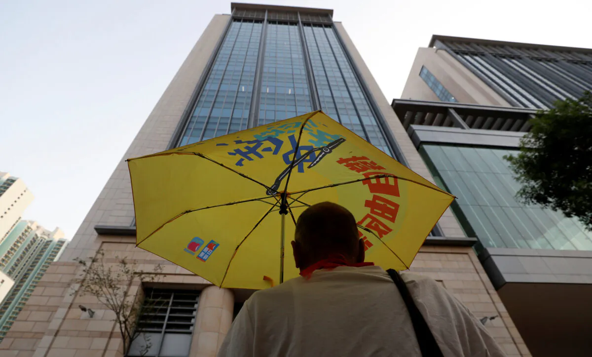 A man holds an umbrella, as forty-four protesters who have been charged with rioting over their actions during a major protest on July 28 are to stand trial at the Eastern Magistrates' Court in Kowloon, Hong Kong, China on Sept. 25, 2019. (Jorge Silva/Reuters)