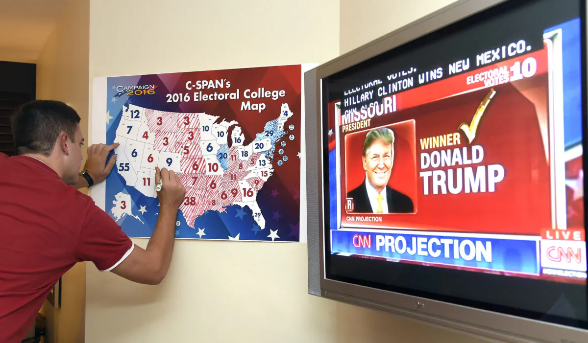 Jake Krupa colors in an electoral map as states projected for Republican presidential candidate Donald Trump or Democratic Presidential candidate Hillary Clinton at an election watching party in Coconut Grove, Fla, on Nov. 8, 2016. (Rhona Wise/AFP/Getty Images)