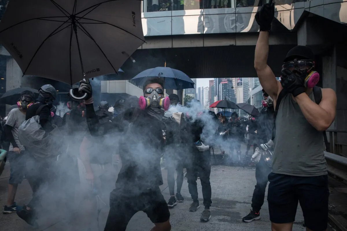 A pro-democracy protester throws a tear gas canister back at police amid clashes during a march in Hong Kong on September 29, 2019. (Chris McGrath/Getty Images)