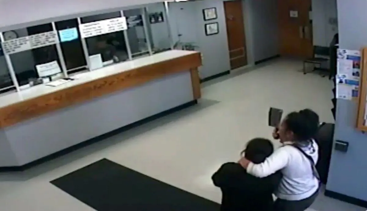A woman armed with a meat cleaver taking another woman hostage in the lobby of the Salinas Police Department in Salinas, Calif., on Sept. 25, 2019. (Salinas Police Department via AP)