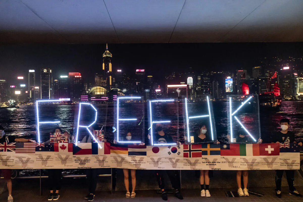 Pro-democracy protesters hold up a sign during a "human chain" demonstration from the Tsim Sha Tsui to Prince Edward neighborhoods, in Hong Kong on September 30, 2019. (Anthony Kwan/Getty Images)