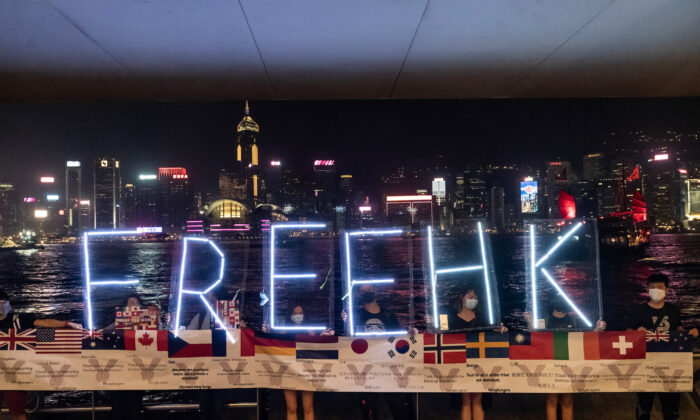 Prodemokratičtí demonstranti drží písmena slova „FREEHK“ (Svobodný Hongkong) během demonstrace ve čtvrti Prince Edwarda v Hongkongu, 30. září 2019. Mezi vlajkami podporujících zemí je také zastoupena vlajka České republiky. (Anthony Kwan / Getty Images)