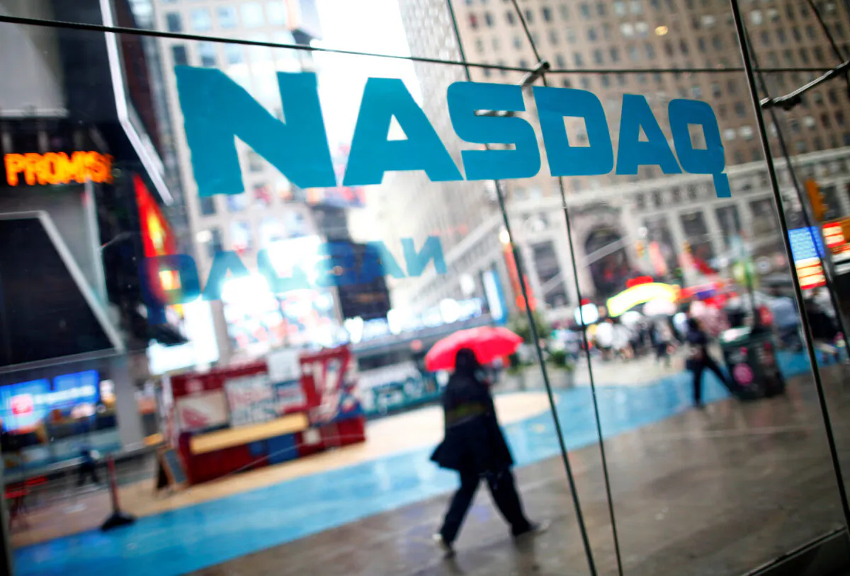 People walk past the NASDAQ MarketSite in New York's Times Square, U.S. on June 4, 2012. (Eric Thayer/Reuters)