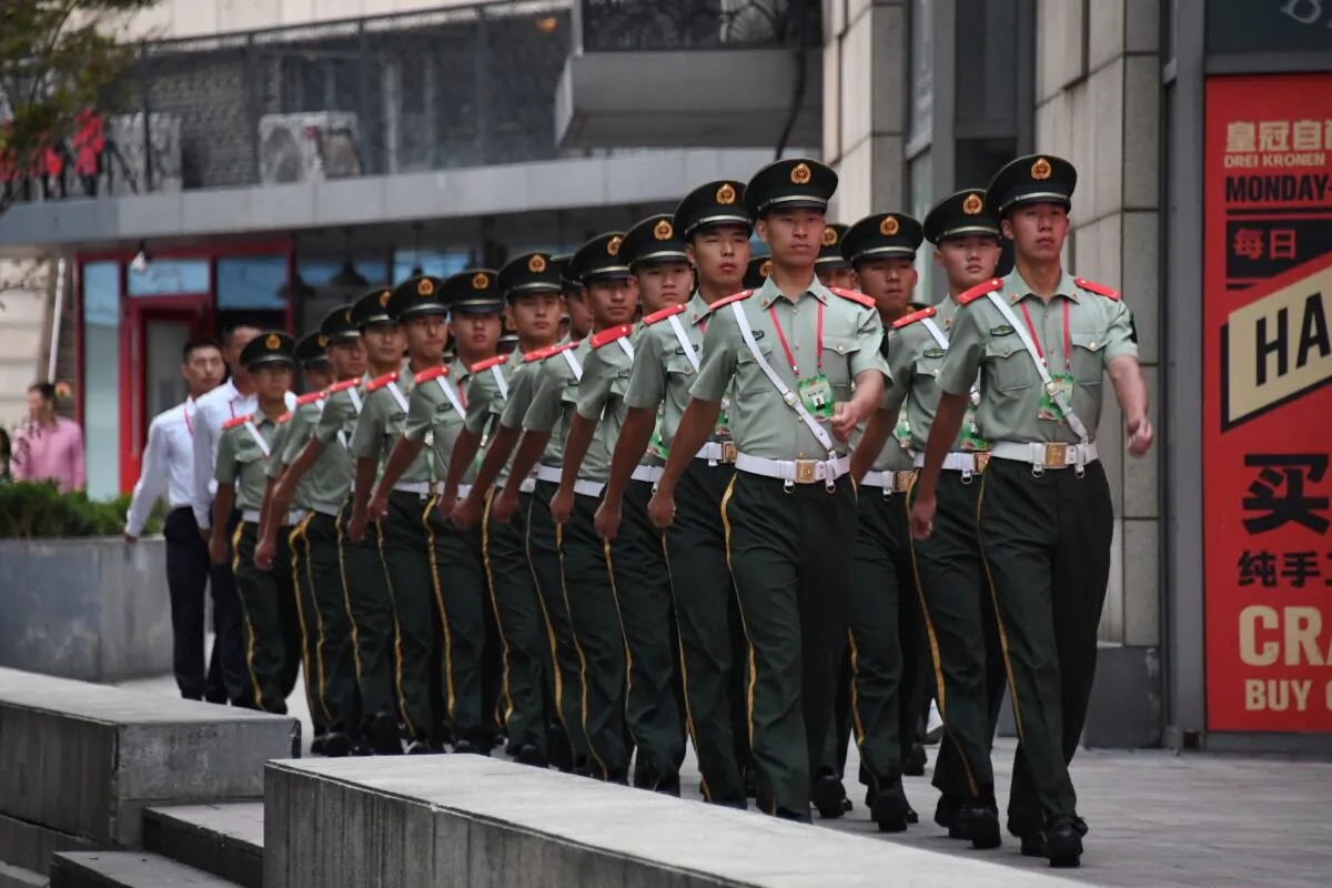 Paramilitary policemen march behind a mall next to the Worker's Stadium, ahead of an overnight rehearsal of a military parade in Beijing on Sept. 14, 2019. (Greg Baker/AFP/Getty Images)