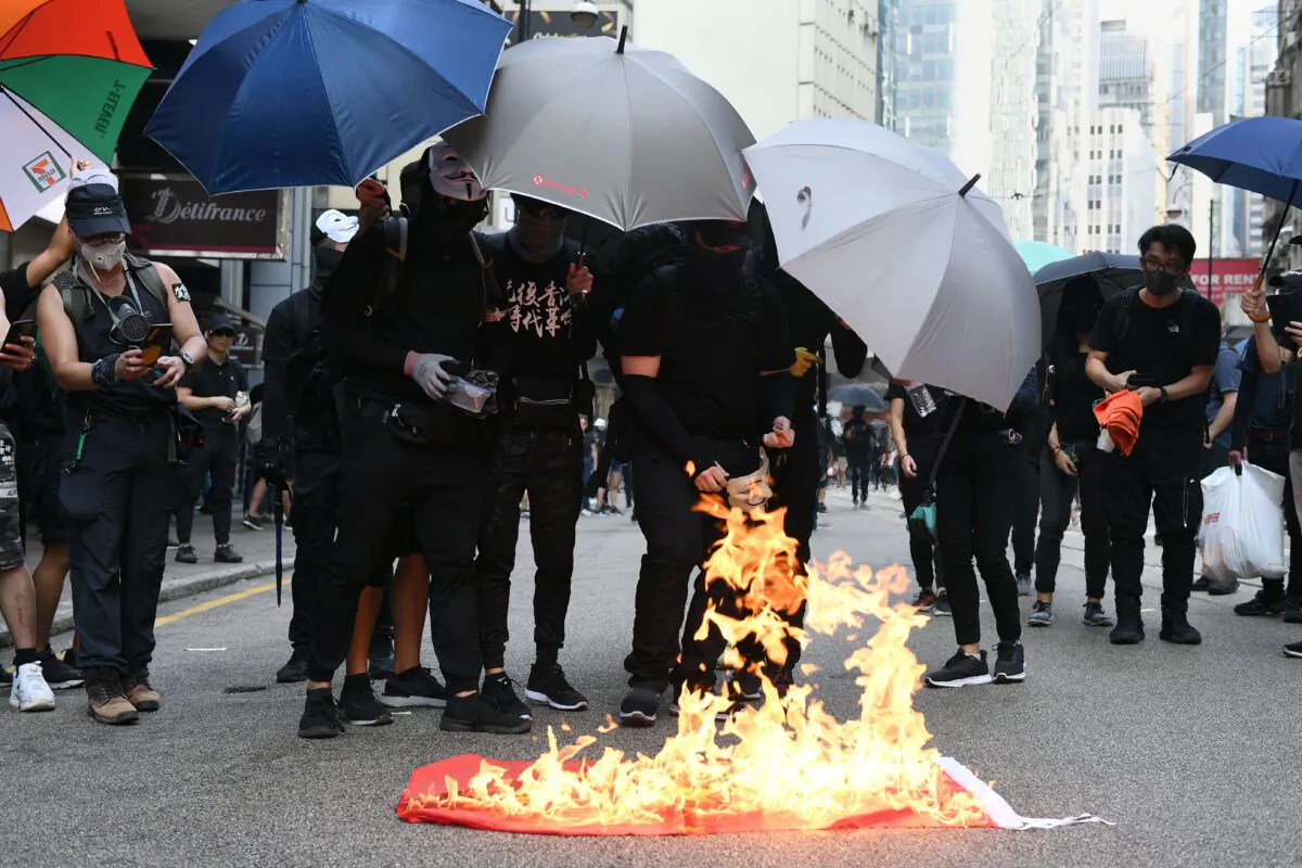 Protesters burn a Chinese national flag during a march through the streets of Hong Kong on Oct. 1, 2019. (Mohd Rasfan/AFP/Getty Images)