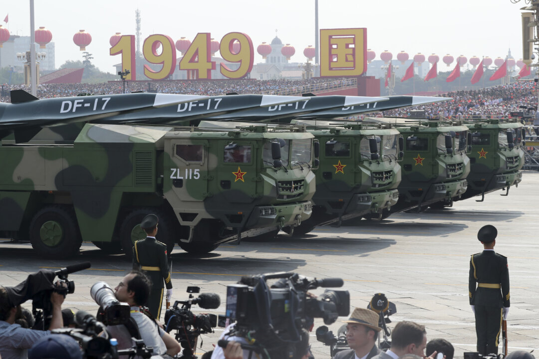 Military vehicles carrying DF-17 roll as members of a Chinese military honor guard march during the parade to commemorate the 70th anniversary of the founding of Communist China in Beijing on Oct. 1, 2019. (AP Photo/Ng Han Guan)