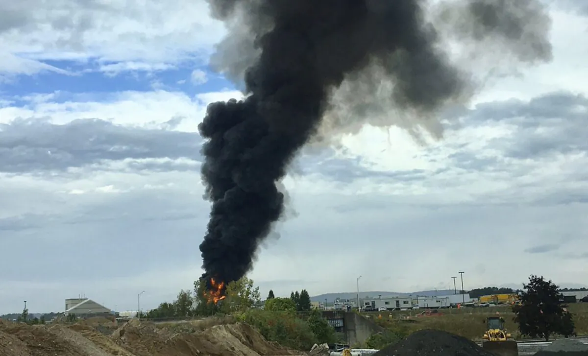 Smoke fills the sky after a World War II-era bomber plane crashed outside Bradley International Airport north of Hartford, Conn. A spokesman for Gov. Ned Lamont confirmed the crash of the B-17 plane on Oct. 2, 2019.  (Antonio Arreguin via AP)