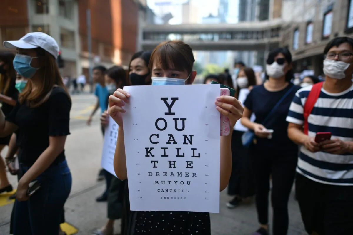 A protester holds a placard, mimicking an eye chart that reads "you can kill the dreamer but you can't kill the dream," during a rally at Chater Garden, Hong Kong on Oct. 2, 2019. (Mohd Rasfan/AFP via Getty Images)