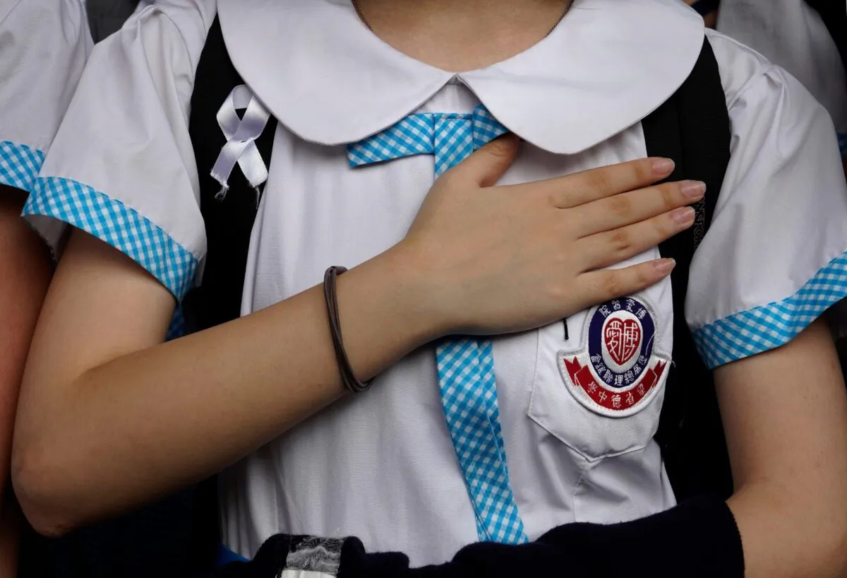 A student puts her hand on her heart during a strike to condemn police shooting of a teenager in Hong Kong on Oct. 2, 2019. (Vincent Yu/AP Photo)