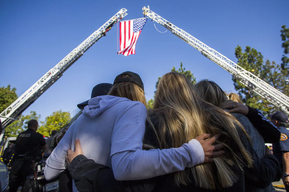 Friends hug outside the Los Robles Medical Center in Thousands Oaks, California on Nov. 8, 2018, as they pay tribute to Ventura County Sheriff Sgt. Ron Helus who was killed in a shooting at Borderline Bar the night before. (Apu Gomes/AFP/Getty Images)