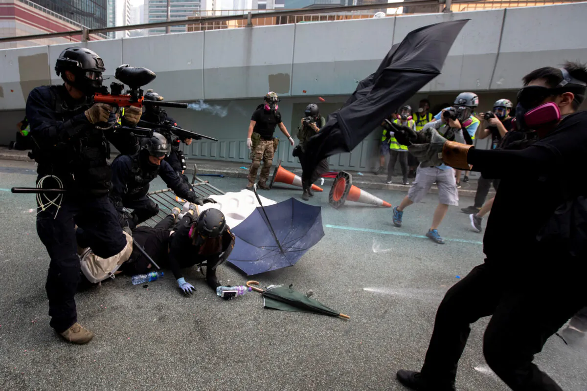 A riot police officer fires pepper-spray projectile toward protesters demonstrating near the Legislative Council building in Hong Kong, China on Sep. 29, 2019. (Athit Perawongmetha/Reuters)
