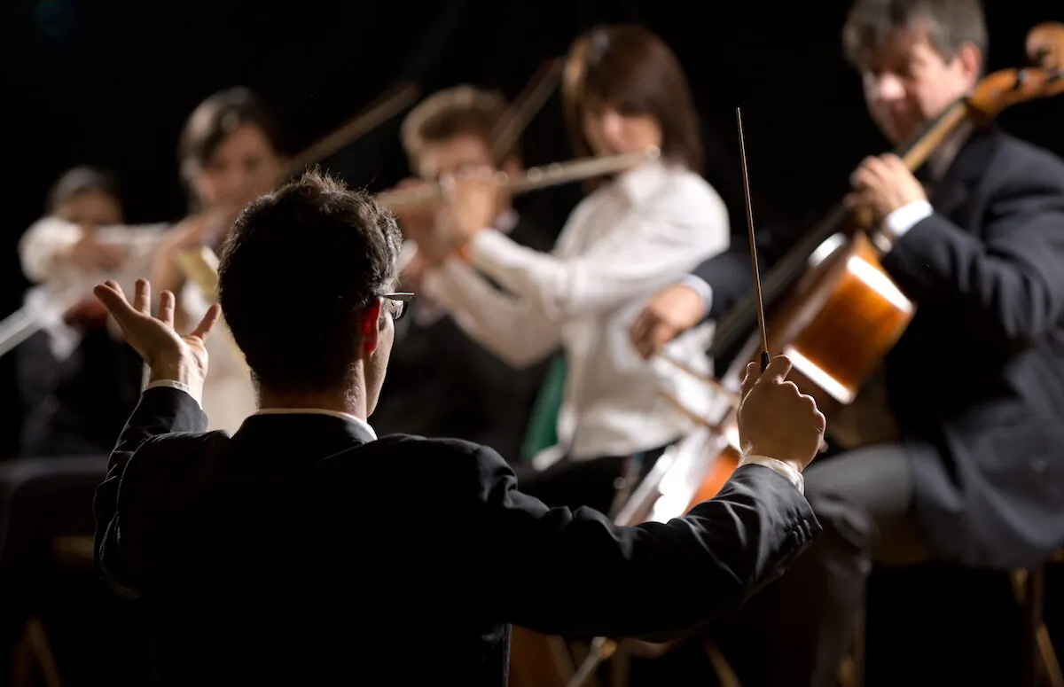 The conductor’s role is to communicate with the performers and their audience. Their role is part artistic, part mathematical. (Shutterstock)