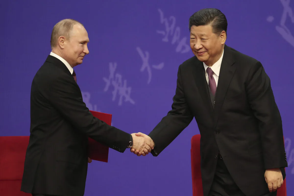 Russian President Vladimir Putin shakes hands with Chinese leader Xi Jinping during the Tsinghua University ceremony in Beijing, China, on April 26, 2019. (Kenzaburo Fukuhara/Pool/Getty Images)