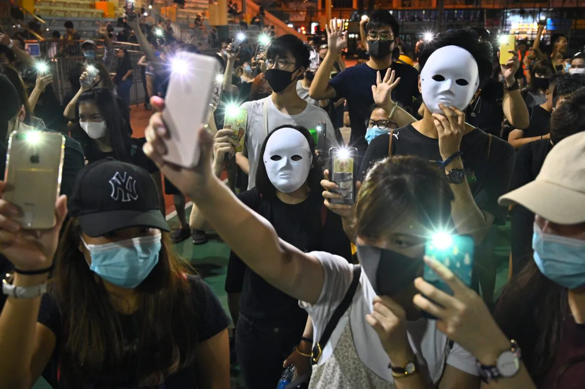 People wear masks and light up their mobile phones during a flash mob rally in the Sham Shui Po district in Hong Kong on Oct. 5, 2019. (Philip Fong/AFP/Getty Images)