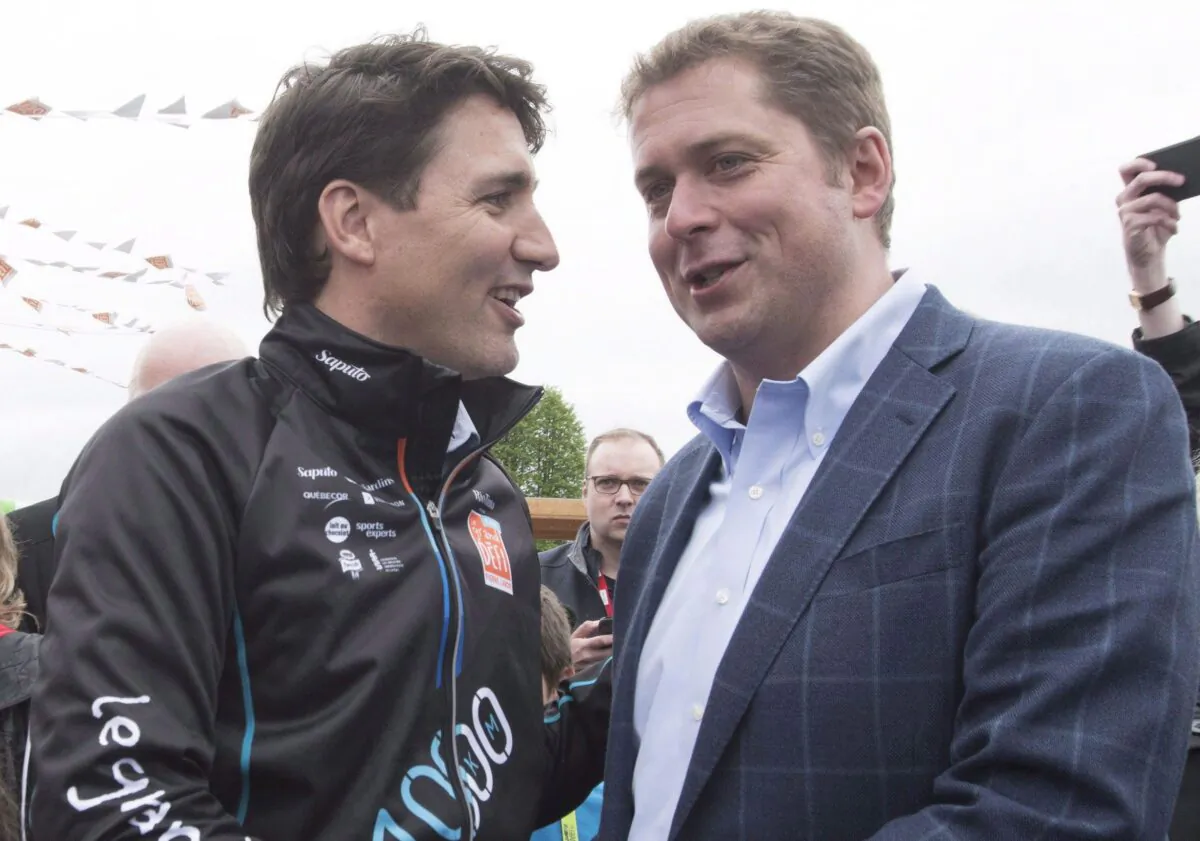 Prime Minister Justin Trudeau shakes hand with Conservative Leader Andrew Scheer at the start of the Defi Pierre Lavoie bicycle trek in Saguenay, Quebec, on June 14, 2018. Trudeau and Scheer, the two front-runners in the election campaign, traded barbs as they attended events in Ottawa today ahead of the leaders’ debate tonight. (THE CANADIAN PRESS/Jacques Boissinot)