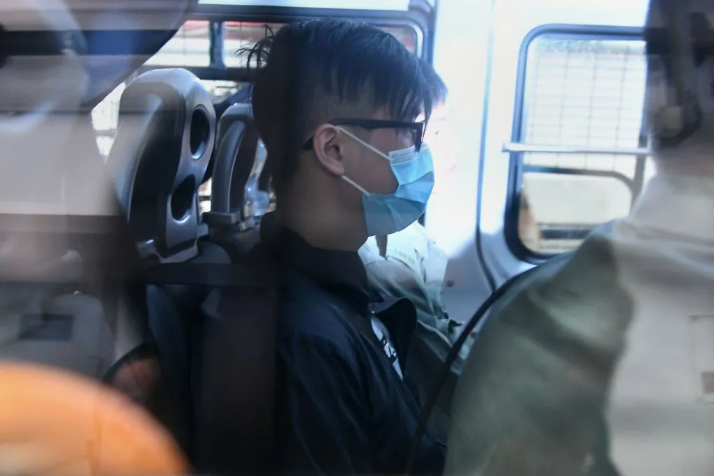 A man (C) wearing a face mask arrives in a police vehicle to the Eastern District Courts in Hong Kong on Oct. 7, 2019, where the first protesters arrested for wearing face masks appeared in court. (Mohd Rasfan/AFP via Getty Images)