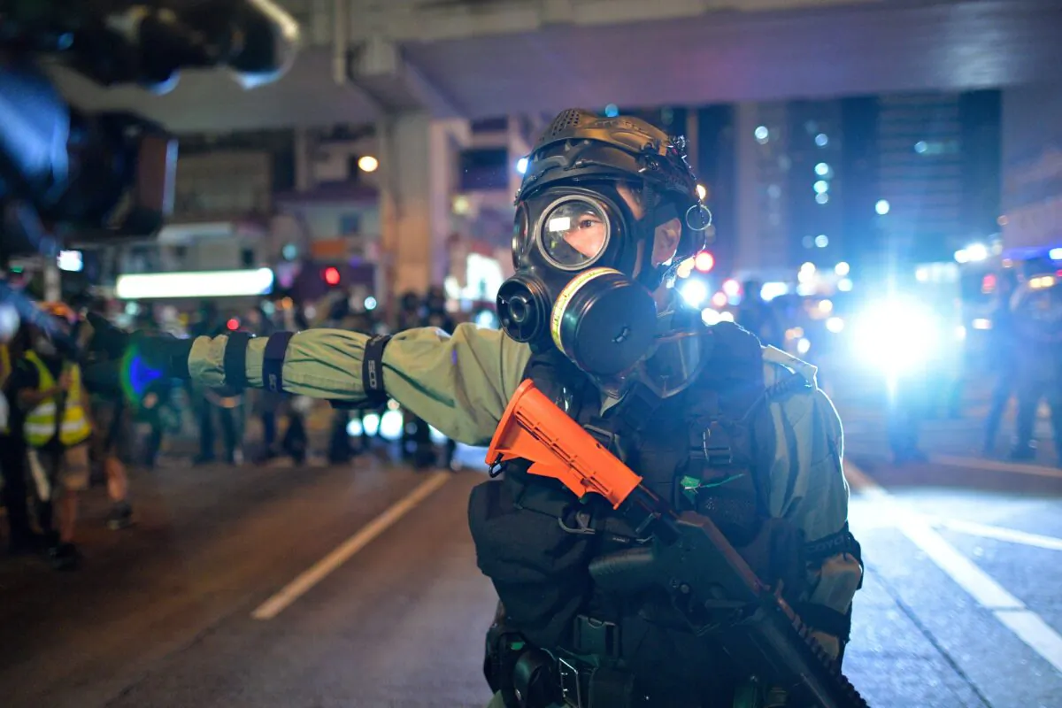 Riot police stand on a street as protesters and pedestrians gather near the Mong Kok police station in Hong Kong on Oct. 7, 2019. (NICOLAS ASFOURI/AFP via Getty Images)