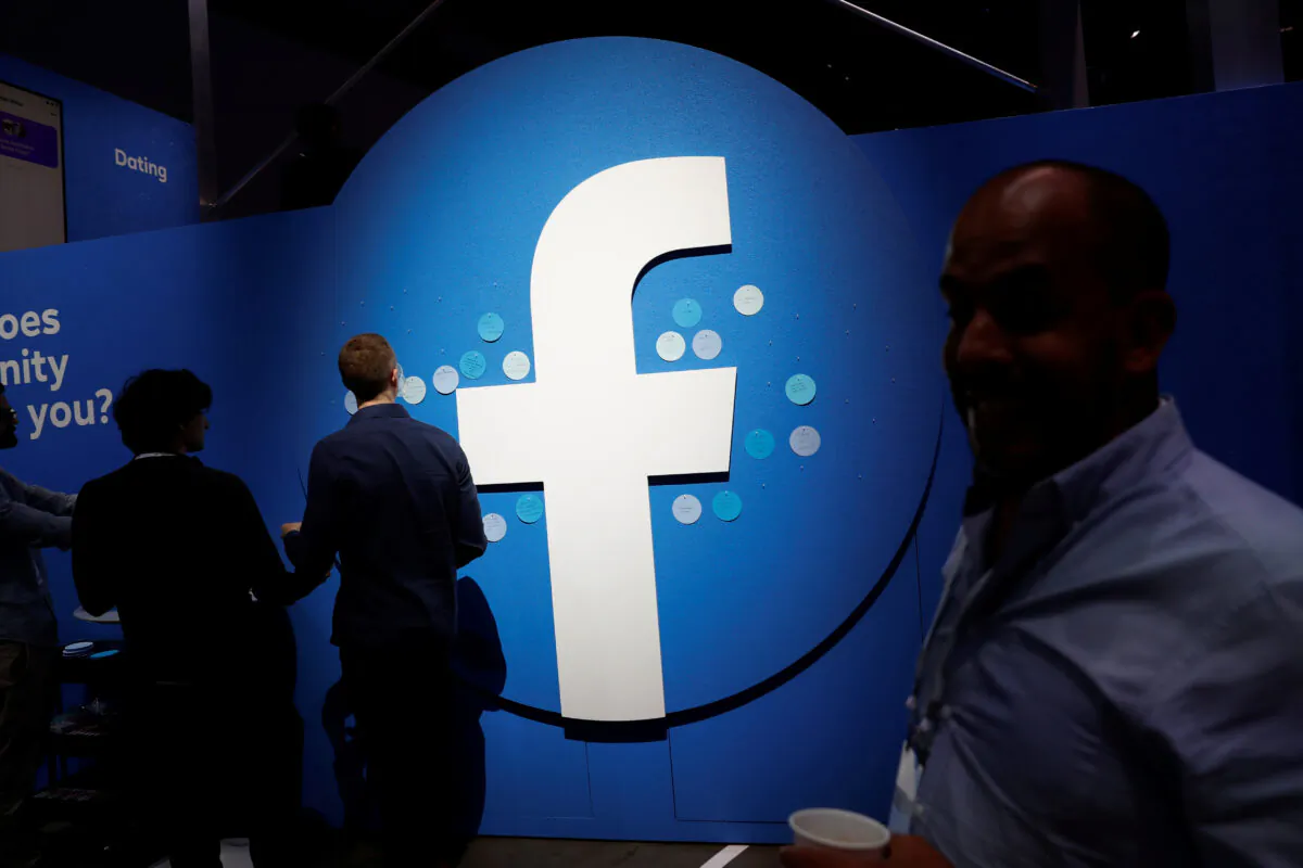 Attendees walk past a Facebook logo during Facebook Inc.'s F8 developers conference in San Jose, Calif., on April 30, 2019. (Stephen Lam/Reuters)