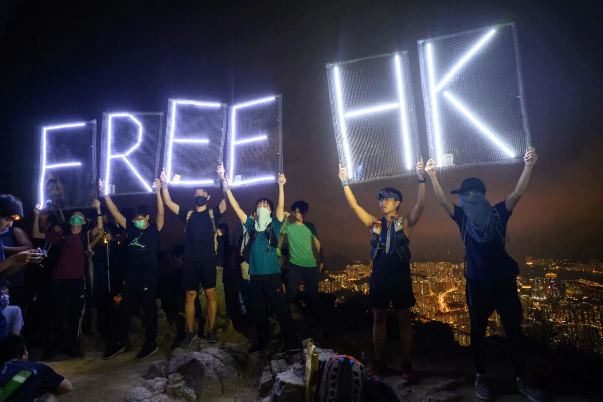 Pro-democracy activists hold up LED lit letters which read "Free HK" while forming a human chain on Lion Rock in Hong Kong on Sept. 13, 2019. An NBA fan in America said he was ejected for shouting "Free Hong Kong" on Oct. 8, 2019. (Anthony Wallace/AFP via Getty Images)