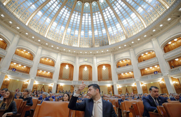 A Romanian member of parliament gives a thumbs up during procedures ahead of a no confidence vote in Bucharest, Romania, Thursday, Oct. 10, 2019. (Vadim Ghirda/AP Photo)