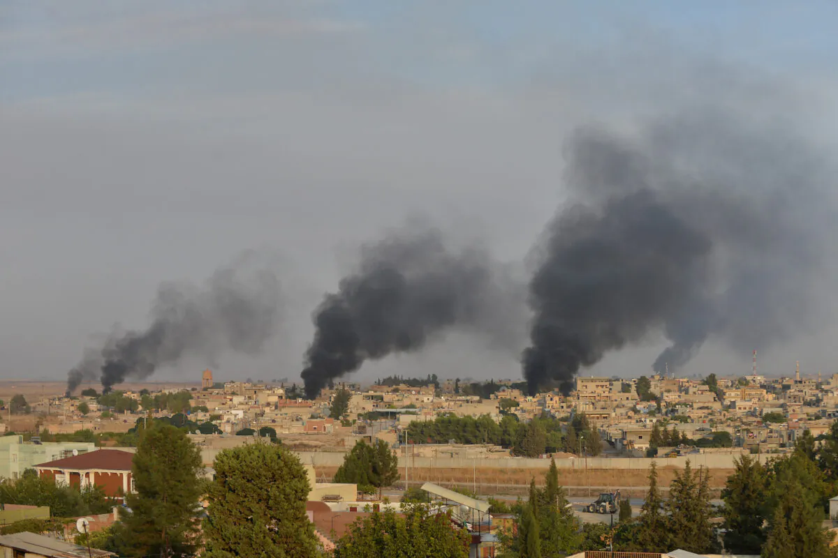 Smoke rises from the Syrian border town of Ras al-Ain as it is pictured from the Turkish town of Ceylanpinar in Sanliurfa province, Turkey, Oct. 9, 2019. (Reuters/Stringer)