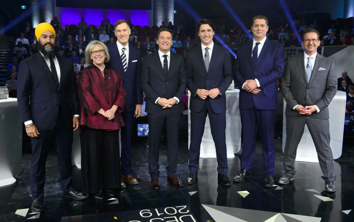 Host Patrice Roy from Radio-Canada (C) with federal party leaders (L-R) NDP Leader Jagmeet Singh, Green Party Leader Elizabeth May, People's Party Leader Maxime Bernier, Liberal Leader Justin Trudeau, Conservative Leader Andrew Scheer, and Bloc Quebecois Leader Yves-Francois Blanchet before the Federal leaders French-language debate in Gatineau, Que., on Oct. 10, 2019. (THE CANADIAN PRESS/Sean Kilpatrick)