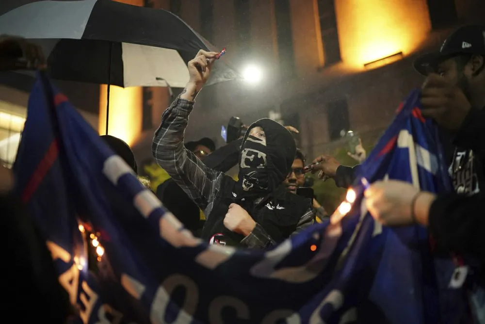 Protesters burn a banner outside President Donald Trump's campaign rally at the Target Center, in Minneapolis, on Oct. 10, 2019, in Minneapolis. (Jeff Wheeler/Star Tribune via AP)