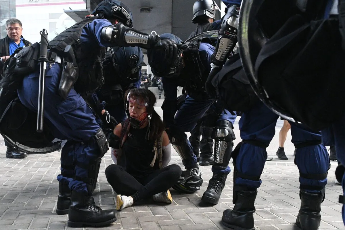 Hong Kong police detain a woman (on ground) near the central government offices after thousands took part in an unsanctioned march through Hong Kong on Sept. 29, 2019. (Mohd Rasfan/AFP via Getty Images)