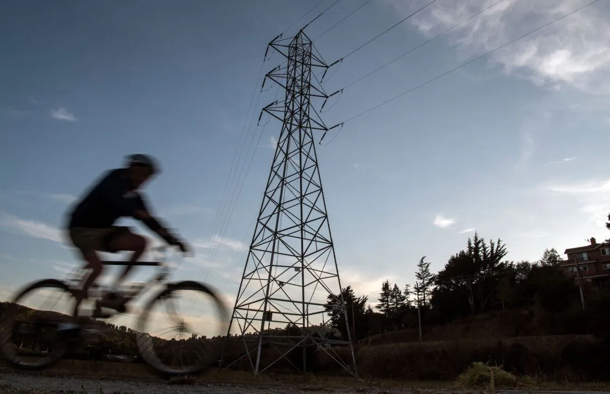 A bicyclist rides passed high-tension power lines in Mill Valley, California as a statewide blackout continues on Oct., 10, 2019. (Josh Edelson/AFP via Getty Images)