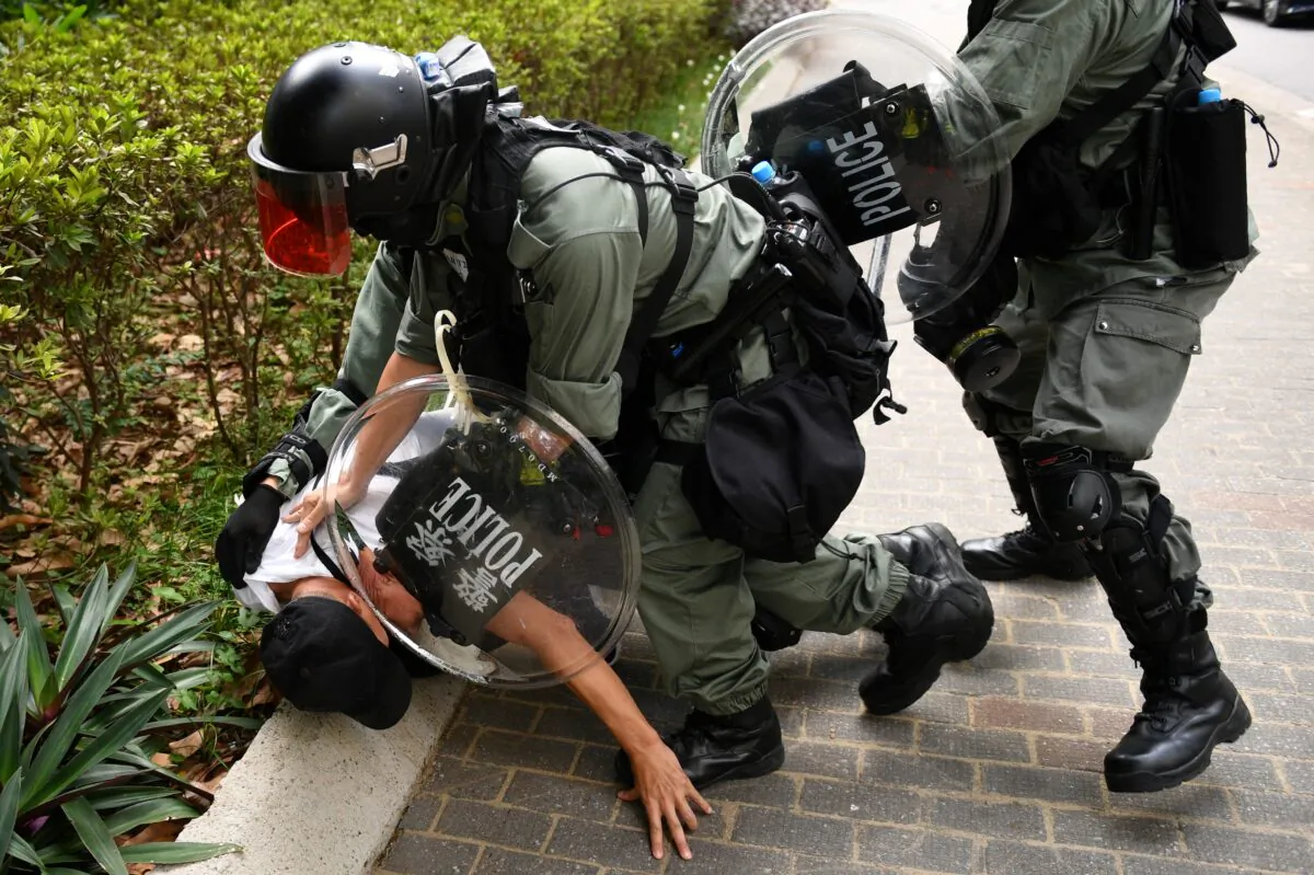 Hong Kong police detain a man for an unknown reason outside a shopping center in the Tai Koo area of Hong Kong, China on Oct. 13, 2019. (Mohd Rasfan/AFP via Getty Images)