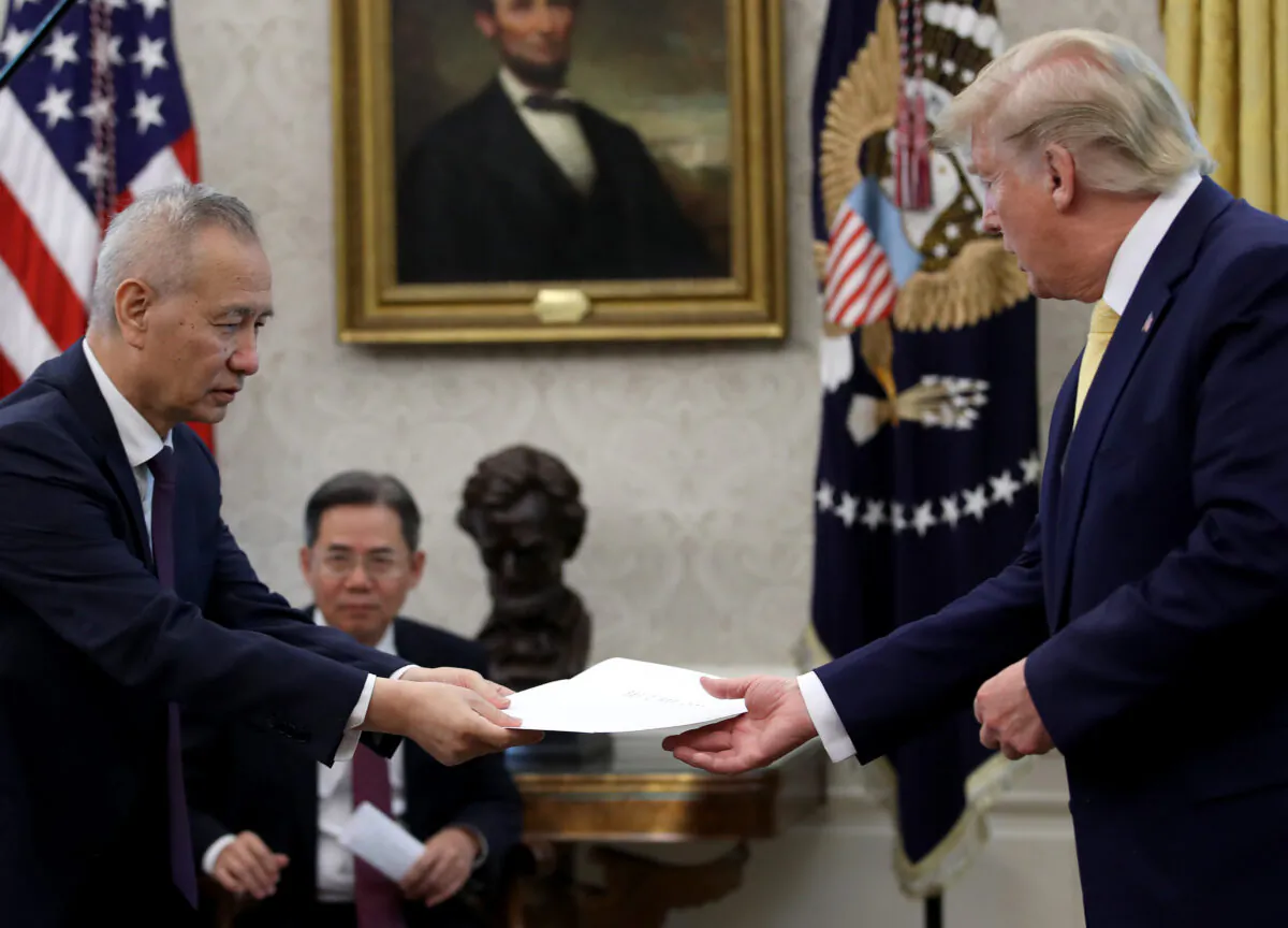 Chinese Vice Premier Liu He presents U.S. President Donald Trump with a letter from Chinese leader Xi Jinping after Trump announced a "phase one" trade agreement was reached with China in the Oval Office at the White House in Washington, DC on October 11, 2019. (Win McNamee/Getty Images)
