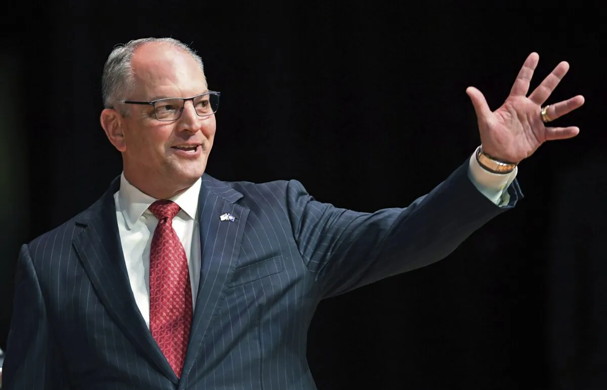 Gov. John Bel Edwards acknowledges his supporters as he comes out onstage for a debate with Eddie Rispone and Republican Rep. Ralph Abraham in Baton Rouge, La., on Sept. 19, 2019. (Bill Feig/The Advocate via AP)