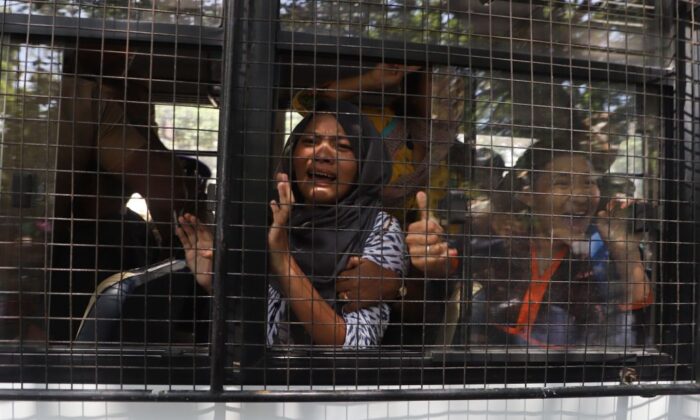 Tibetan students react inside a police vehicle after being detained during a protest against the visit of Chinese leader Xi Jinping near the ITC Grand Chola hotel in Chennai on Oct. 11, 2019. (STR/AFP via Getty Images)