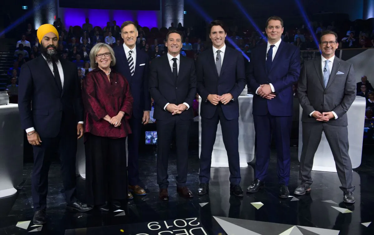 Host Patrice Roy from Radio-Canada (C) with federal party leaders (L-R) NDP Leader Jagmeet Singh, Green Party Leader Elizabeth May, People's Party Leader Maxime Bernier, Liberal Leader Justin Trudeau, Conservative Leader Andrew Scheer, and Bloc Quebecois Leader Yves-Francois Blanchet before the leaders’ French-language debate in Gatineau, Que., on Oct. 10, 2019. (THE CANADIAN PRESS/Sean Kilpatrick)