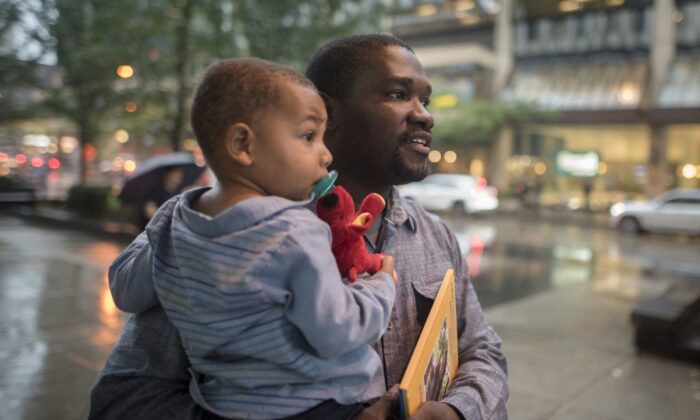 Cialin Dany holds his son Evan, after attending a memorial service for his wife Alishia Liolli, who died in hurricane Dorian in the Bahamas, in Toronto on Oct. 1, 2019.   (THE CANADIAN PRESS/ Tijana Martin)