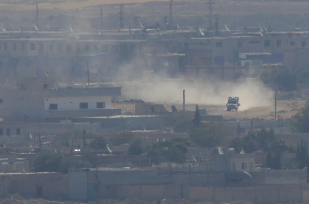 A vehicle is seen in the Syrian town of Ras al-Ain as seen from the Turkish border town of Ceylanpinar, Sanliurfa province, Turkey, on Oct. 15, 2019. (Stoyan Nenov/Reuters)