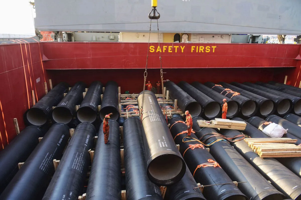 Workers are loading pipes, which will be exported to Africa, at a port in Qingdao, Shandong Province, China, on April 1, 2019. (STR/AFP/Getty Images)