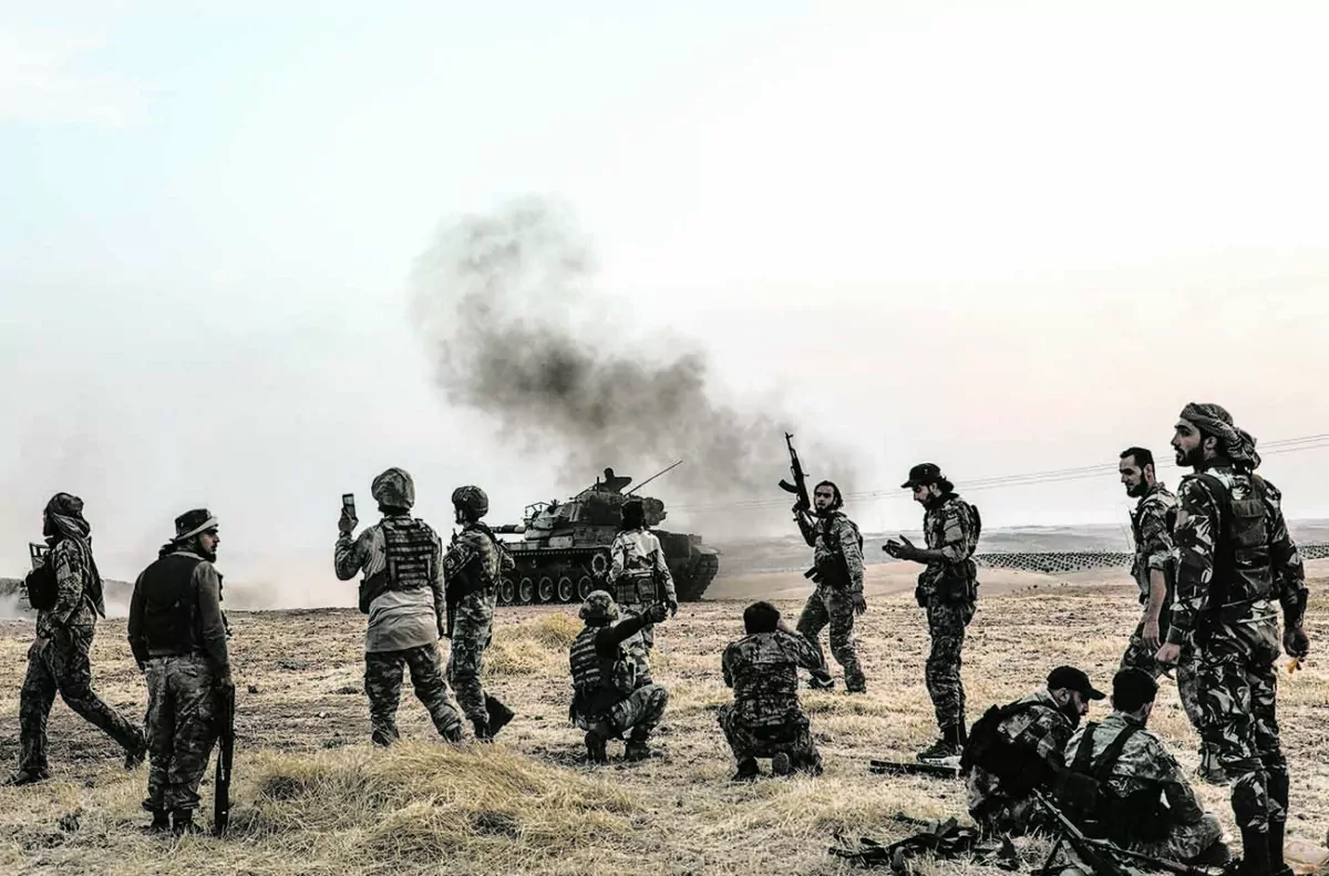 Turkish soldiers and Turkey-backed Syrian fighters gather on the northern outskirts of the Syrian city of Manbij near the Turkish border on Oct. 14, 2019. Turkey wants to create a roughly 20-mile buffer zone along its border to keep Kurdish forces at bay. (Zein Al Rifai/AFP via Getty Images)