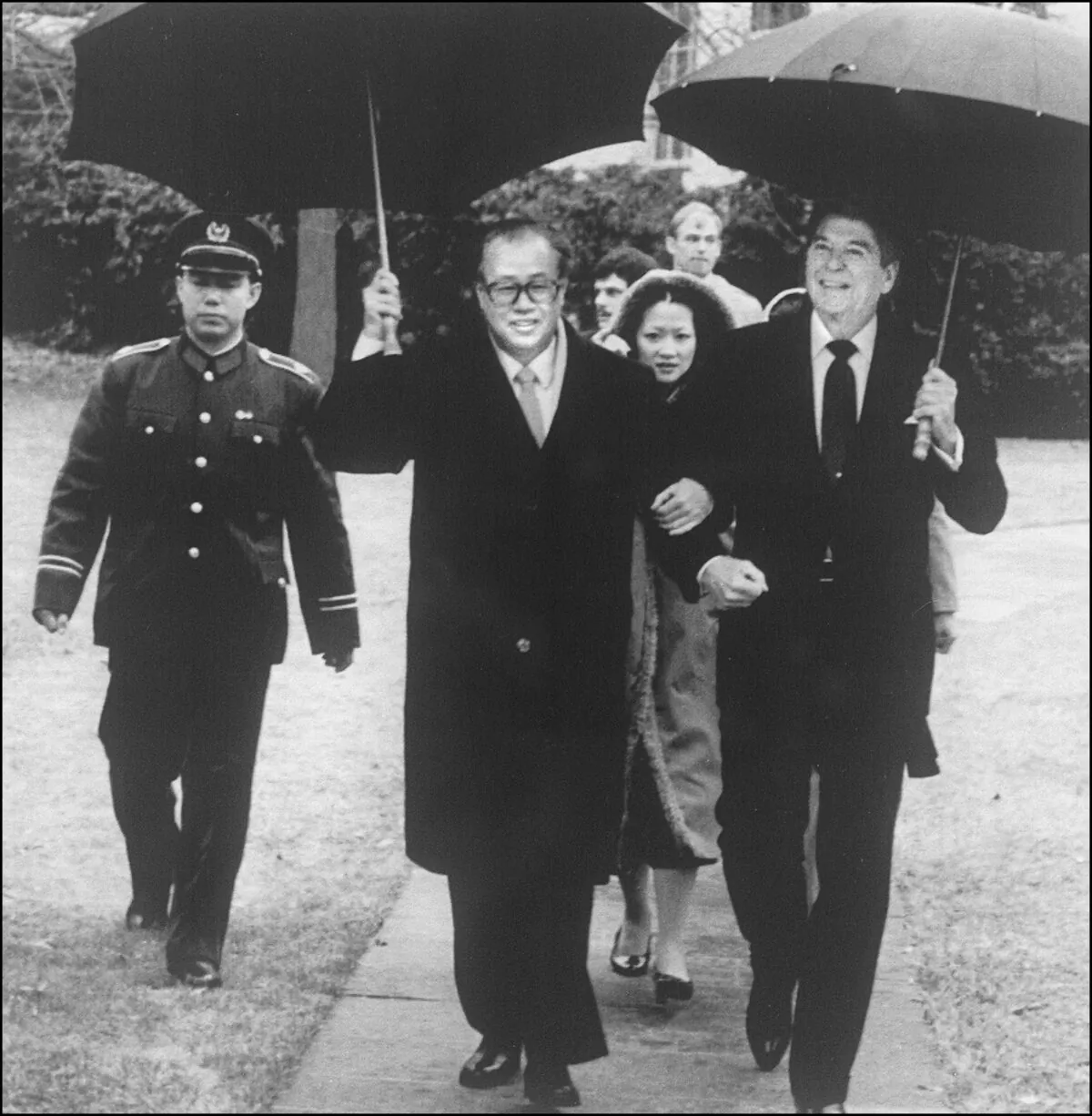 U.S. President Ronald Reagan and Chinese Premier Zhao Ziyang, both holding umbrellas, are walking arm in arm after a meeting in the Cabinet Room at the White House, Washington, D.C. on October 1, 1984. (AFP/AFP/Getty Images)