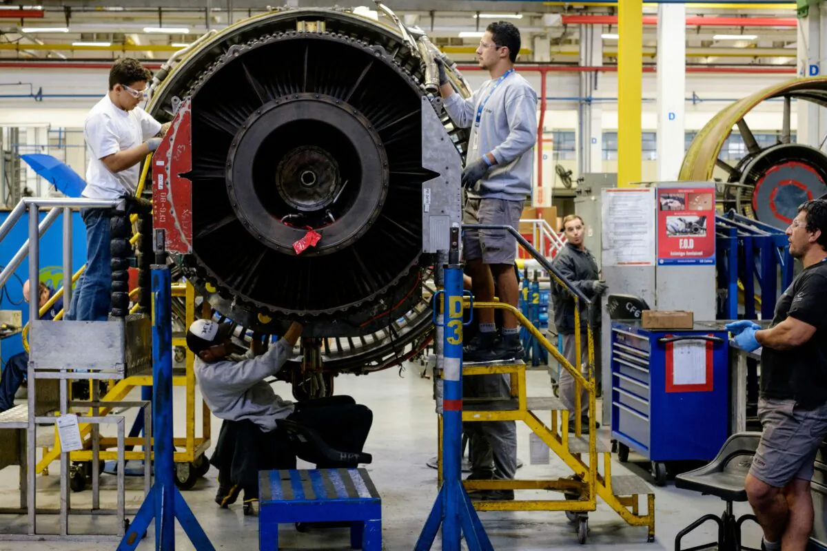 Men work with a jet engine at a General Electric (GE) aviation engine overhaul facility in Petropolis, Rio de Janeiro, Brazil on June 8, 2016. (Yasuyoshi Chiba/AFP/Getty Images)