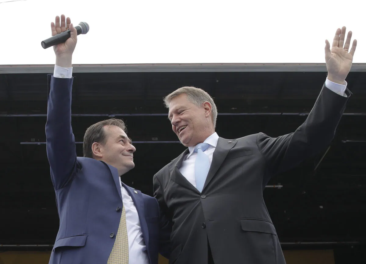 Liberal party President Ludovic Orban (L) and Romanian President Klaus Iohannis wave on stage during an European Parliament electoral rally in Bucharest, Romania on May 18, 2019. (Vadim Ghirda/AP Photo, File photo)