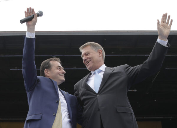 Liberal party President Ludovic Orban (L) and Romanian President Klaus Iohannis wave on stage during an European Parliament electoral rally in Bucharest, Romania on May 18, 2019. (Vadim Ghirda/AP Photo, File photo)