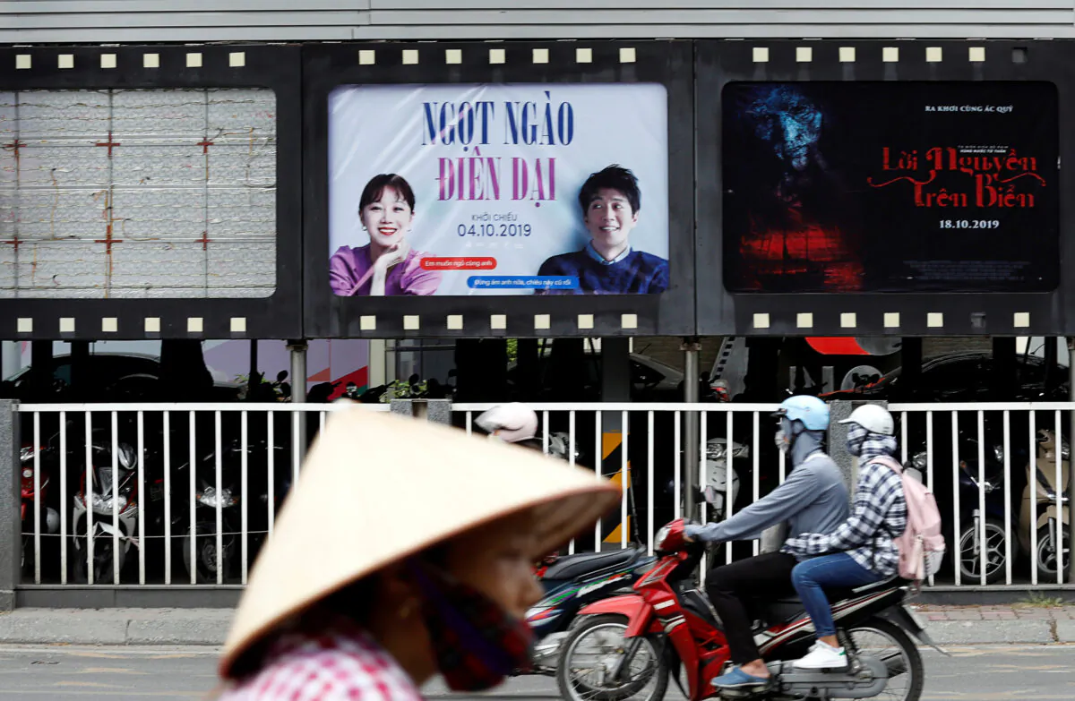 Bikers go past an empty space where a promotional poster for the DreamWorks film "Abominable" stood before being taken down at a cinema in Hanoi, Vietnam on Oct. 14, 2019. (Kham/Reuters)