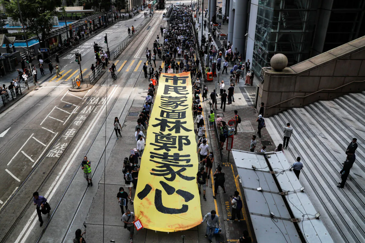 People march with a banner to protest against what they say is the abuse of pro-democracy protesters by Hong Kong police, near Chater Garden in Central district, Hong Kong, China on Oct. 18, 2019. (Ammar Awad/Reuters)